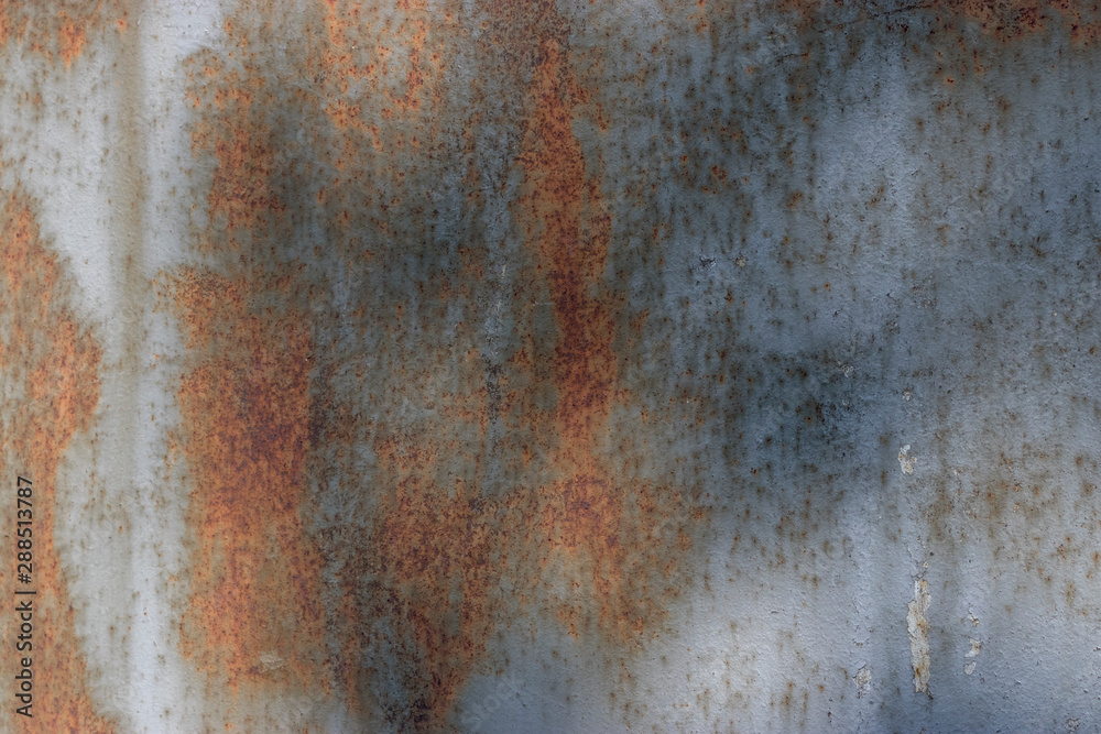 Orange rust on a metal wall in the sunlight