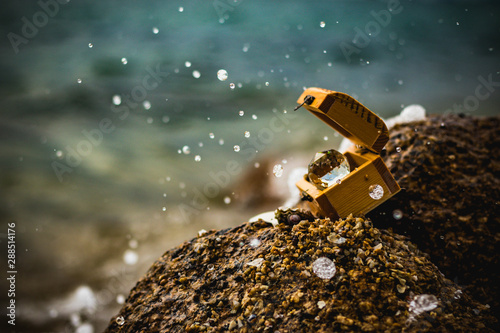 Treasure chests on rocks and ocean waves in the background