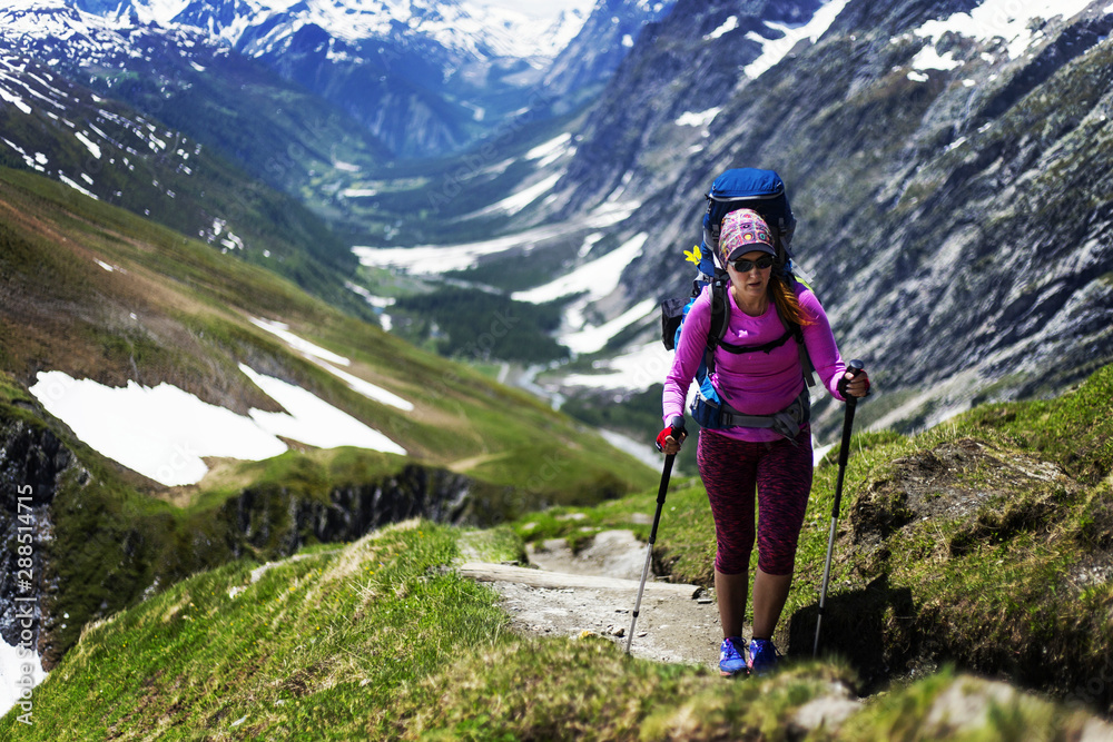 Traveling girl with backpack hiking in the mountains, freedom concept. Hiking people on Asia. Beautiful young woman traveler with a backpack looks at the mountain top before climbing