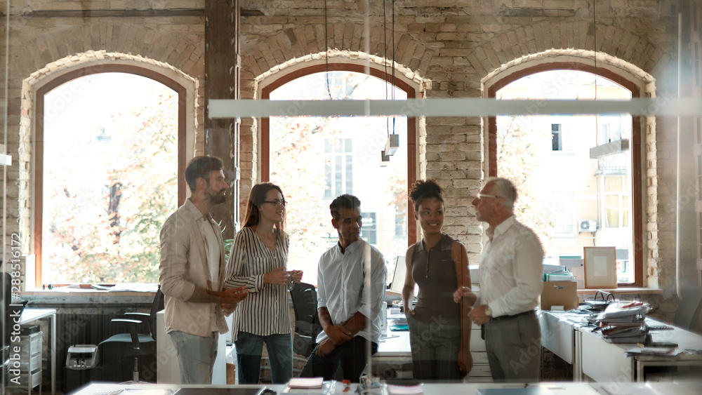Business team. Group of modern people discussing something at business meeting while standing in the modern office