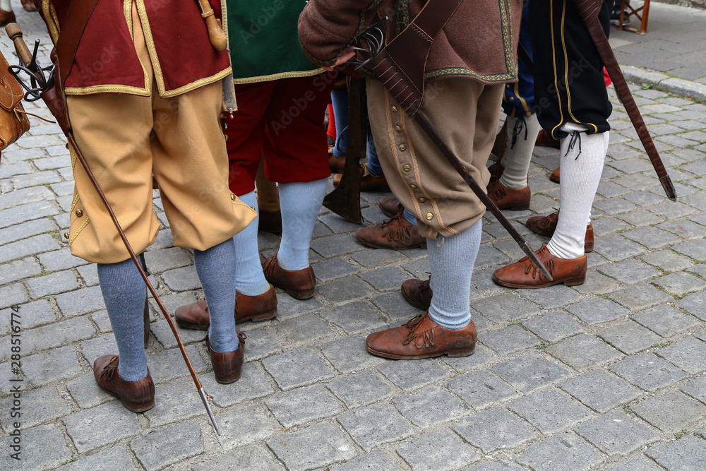 Reconstructors in musketeers clothes on a city holiday