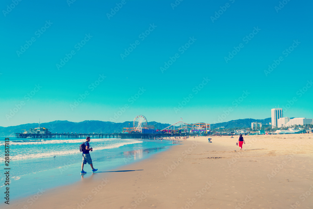 Photographer walking in world famous Santa Monica beach