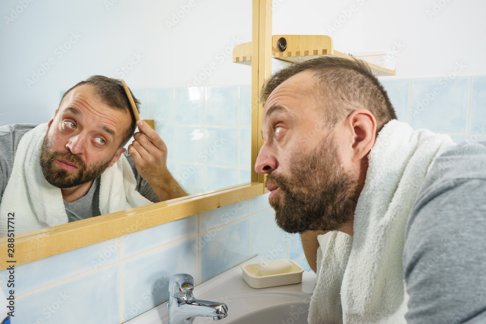 Man using comb in bathroom Man using comb in bathroom