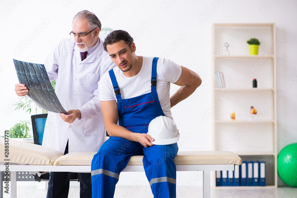 Obraz premium Young male contractor visiting old doctor