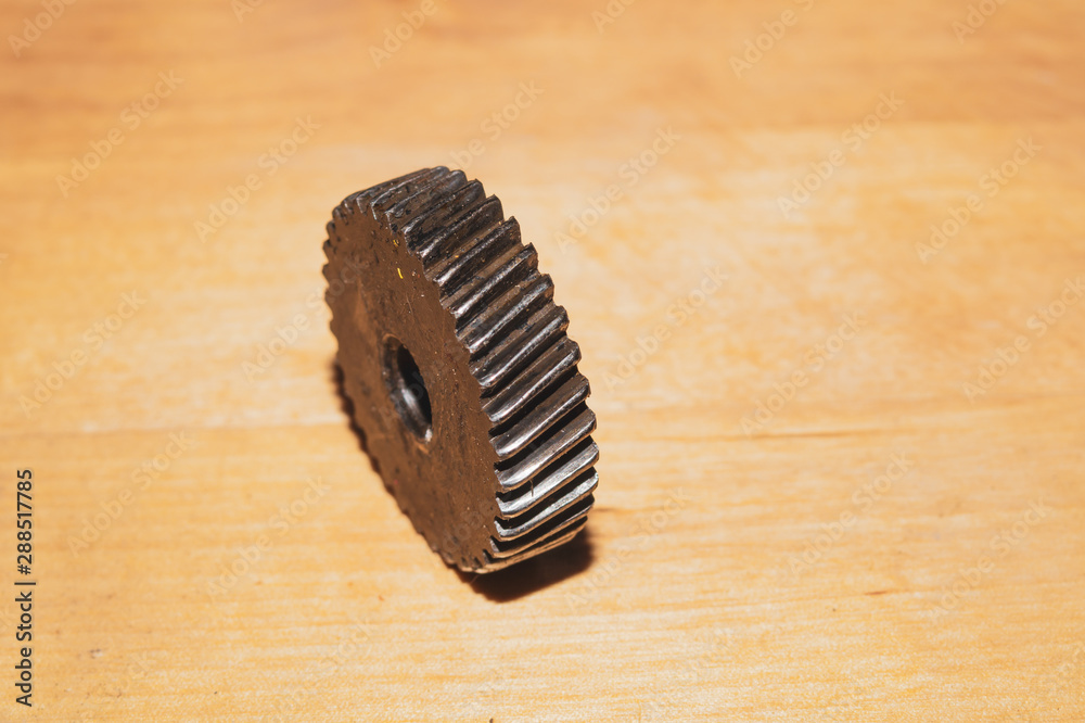 Metal gear on a wood background. detail of mechanism Metal gear on a wood background. detail of mechanism