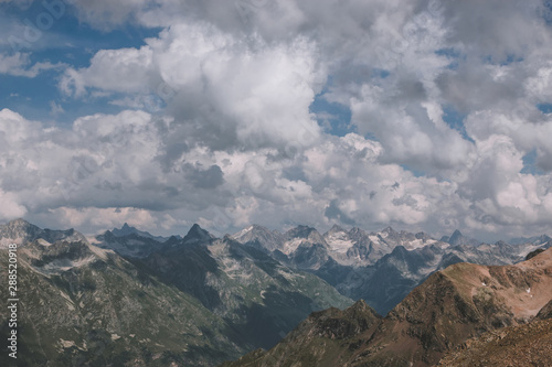 Mountains scene with dramatic cloudy sky in national park of Dombay