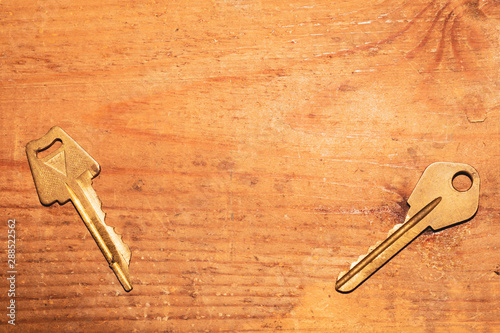 Two keys isolated on a wooden background. safety and security concept