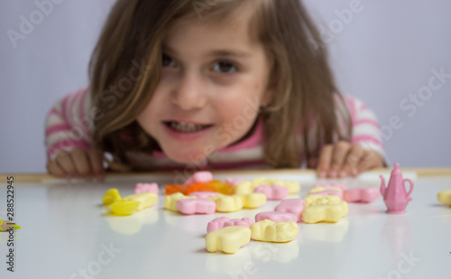 Little girl playing with candies; shallow depth of field