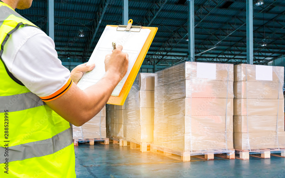 Workers Courier Holding Clipboard Doing Inventory Management The Products in Storage Warehouse. Supply Chain. Shipment Package Boxes. Shipping Warehouse Cargo Logistics and Transportation. - obrazy, fototapety, plakaty 