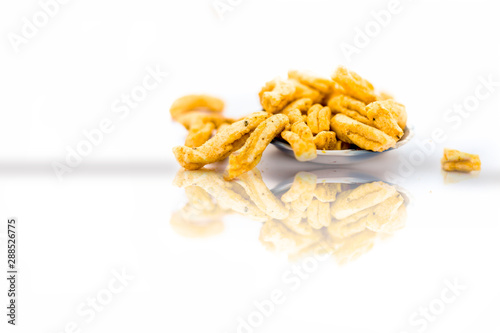 Famous Indian Gujarati snack dish in a glass bowl isolated i.e. Vanela gathia or vanela gathiya.Snack prepared with gram or chickpea flour and black pepper, salt and other ingredients.With reflection photo