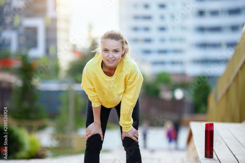 Sport woman in yellow is training in an urban environment.