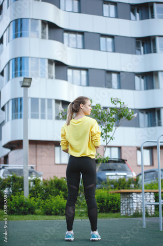 Sport woman in yellow is training in an urban environment.