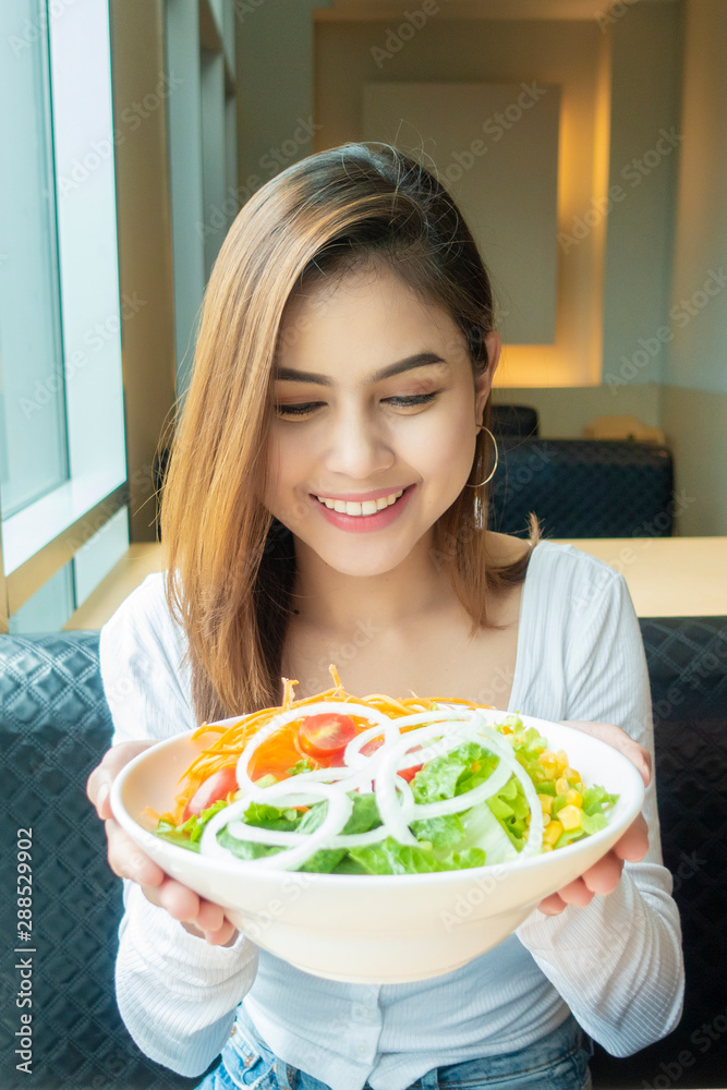 Beautiful healthy woman is holding vegetables salad Beautiful healthy woman is holding vegetables salad