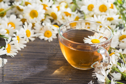 Glass cup with herbal tea with chamomile flowers