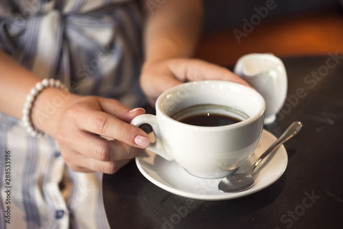Young girl in a cafe with a coffee cup