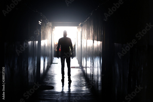 Man walking down a dark corridor
