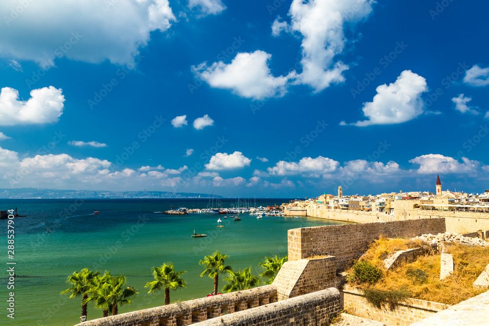 View on marina with yachts and ancient walls of harbor in Acre or Akko, Israel.