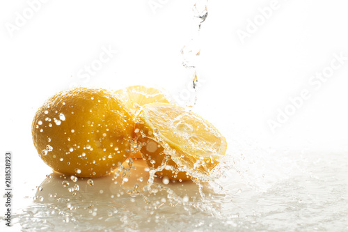 tropical fruit fresh natural lemon with water splash, kitchen table isolated background, organic food and nutrition vitamin citrus, diet and healthy