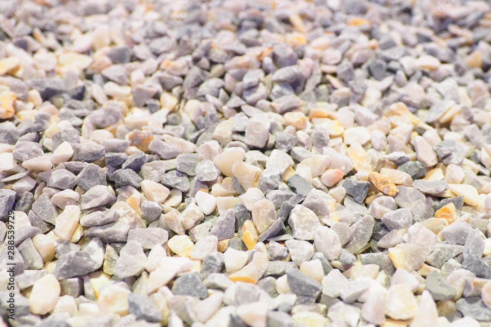 Selective focus of a lot of tiny pieces of gravel on the road in grey tone with rough surface and texture used for construction and also for background and decoration. Selective focus of a lot of tiny pieces of gravel on the road in grey tone with rough surface and texture used for construction and also for background and decoration.