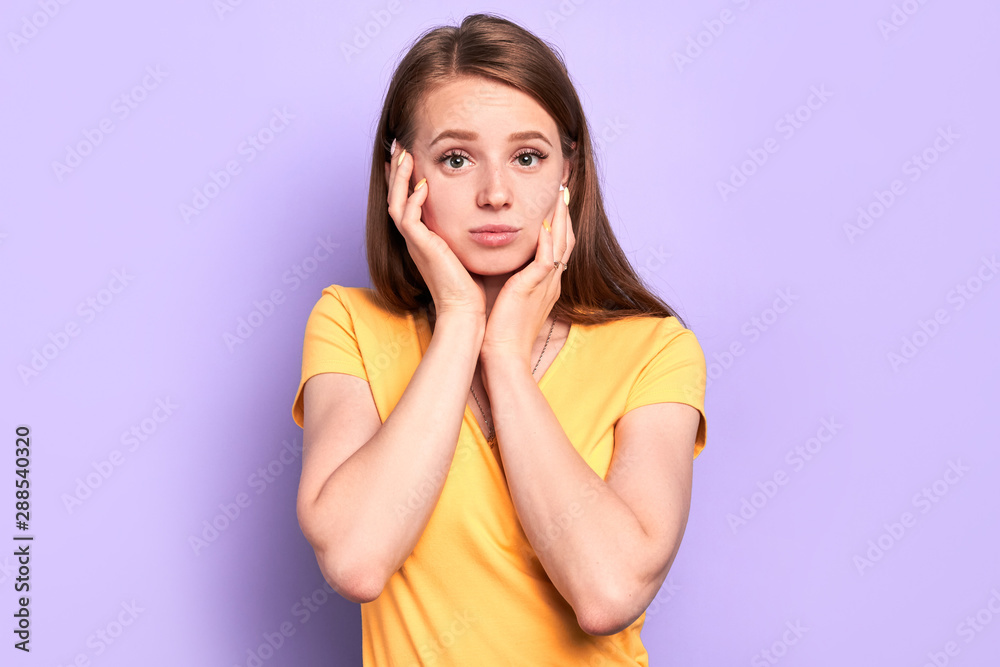 Portrait of amazed thoughtful girl holds face with hands, wonders sudden news, stares in camera with eyes full of shock, tries to keep calm, cant believe in shocking rumors, dressed in casual outfit. Portrait of amazed thoughtful girl holds face with hands, wonders sudden news, stares in camera with eyes full of shock, tries to keep calm, cant believe in shocking rumors, dressed in casual outfit.