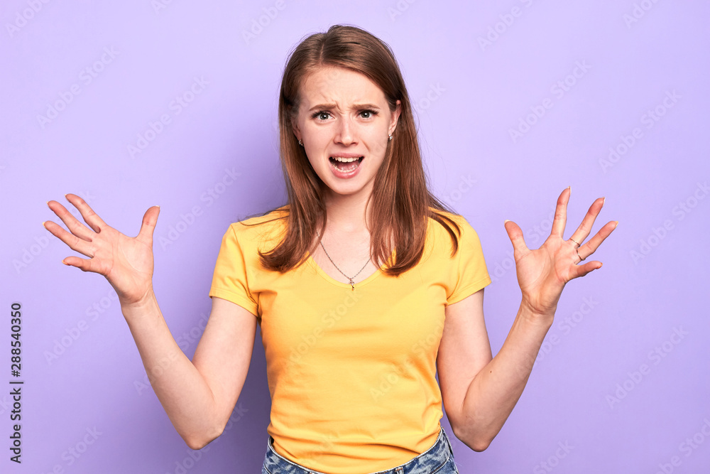 Studio shot of irritated young female office worker keeps hands wide apart, gestures emotionally, opens mouth widely and shouts, angry face, expresses negative emotions and feelings. Studio shot of irritated young female office worker keeps hands wide apart, gestures emotionally, opens mouth widely and shouts, angry face, expresses negative emotions and feelings.