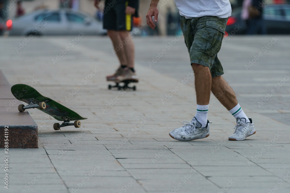 Skateboarder performed trick unsuccessfully on city street in autumn day. Skate flew to the side. He has tough unsafe practice.  Extreme sport among yout