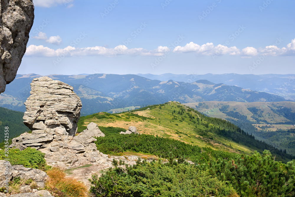 Landscape of high mountains with huge stones on top of the hillside and hills with cloudy sky. Carpathian mountains in summer Landscape of high mountains with huge stones on top of the hillside and hills with cloudy sky. Carpathian mountains in summer