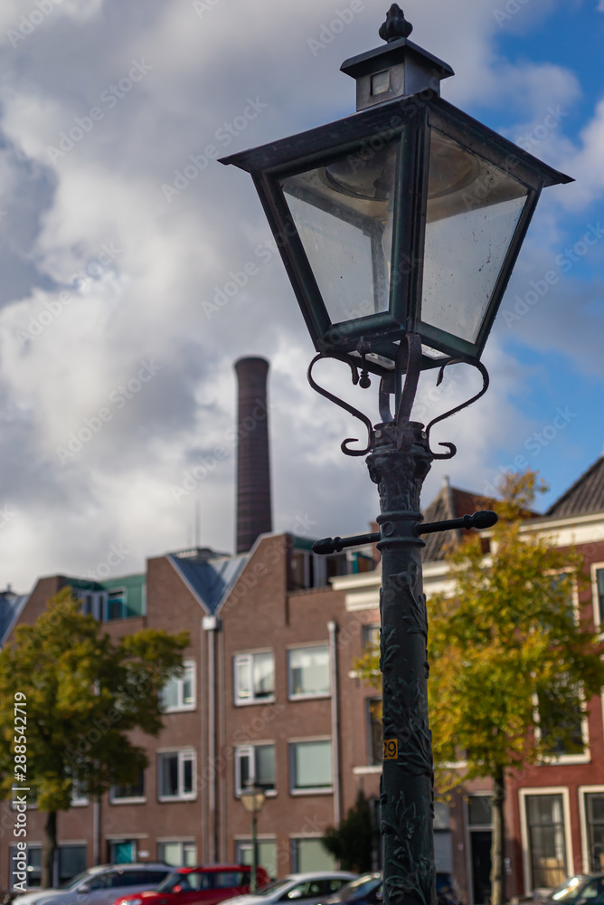 Green lamppost with the power plant chimney in the background
