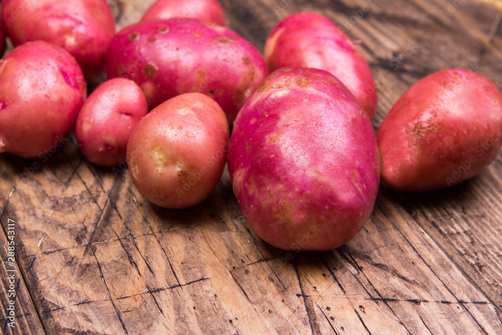 red potatoes on wooden background. Farmers product. red potatoes on wooden background. Farmers product.