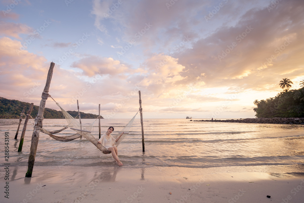 Woman relaxing in the hammock on tropical beach.