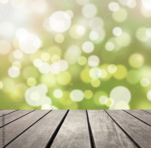 Green bokeh and wooden plank