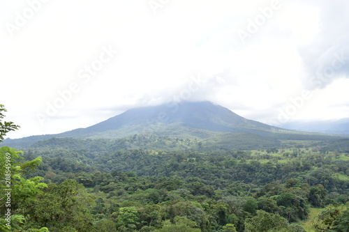 Great Arenal Volcano, surrounded by flowers and vegeration. photo