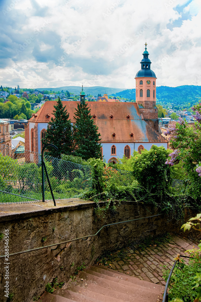Collegiate church Stiftskirche and cityscape with Black forest in Old city in Baden Baden at Baden Wurttemberg region in Germany. View of Bath and spa German town in Europe. Landmark scenery