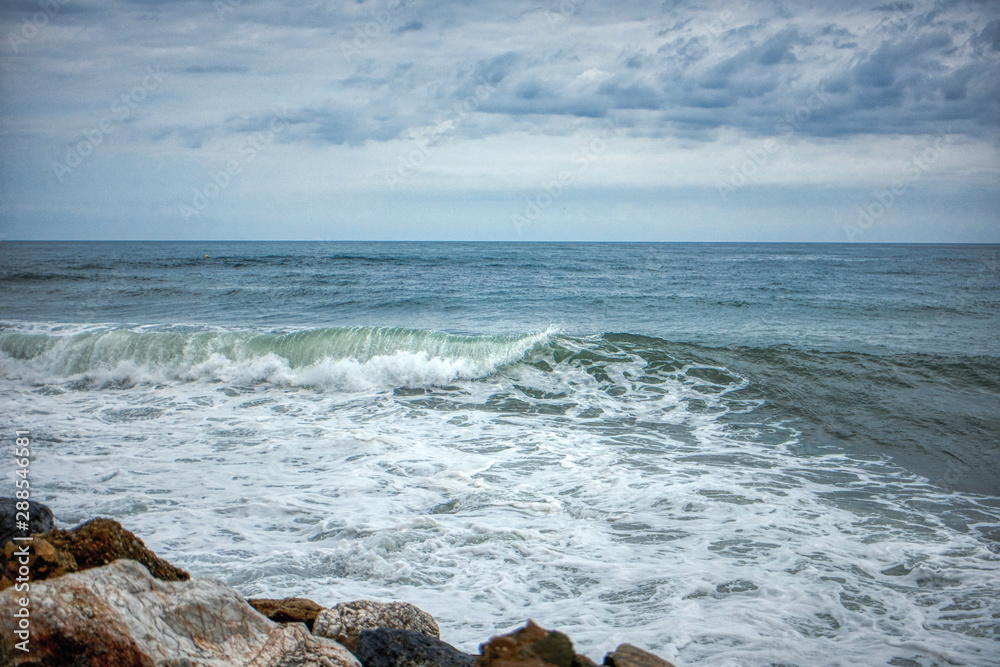 Waves crashing against the rocks by the beach Waves crashing against the rocks by the beach