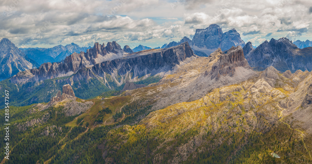Panoramic view of Cinque Torri on a cloudy day with opening peaks of the Julian Alps, Dolomites, Italy