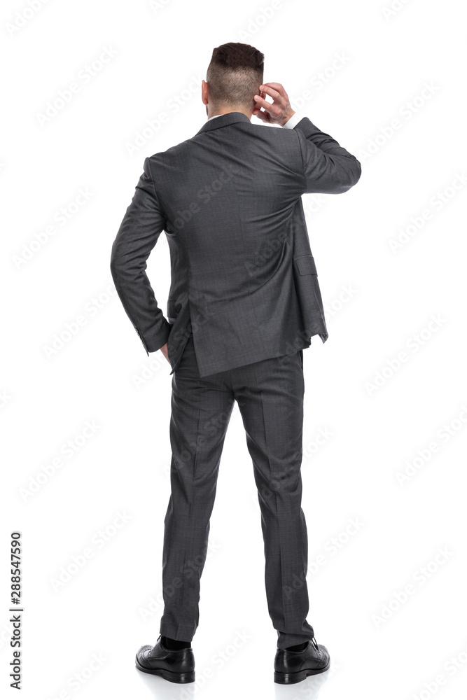 businessman pondering his decision while scratching his head businessman pondering his decision while scratching his head
