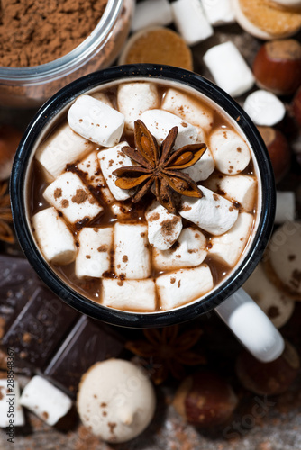 hot chocolate with marshmallows and sweets on wooden background, vertical top view
