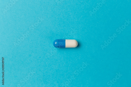 Pharmaceutical medicine pills, tablets and capsules on blue background. Top view. Flat lay. Copy space. Medicine concepts. Minimalistic abstract concept