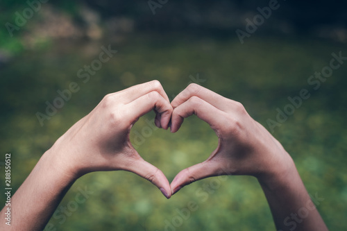 Hand on heart-shaped outdoor © photosky99