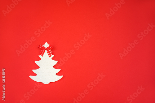 white wooden toy handmade Christmas tree close-up on a red background. winter holidays concept.