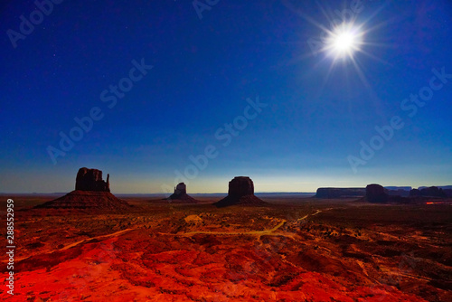View of Monument Valley at night with lots of stars in the sky in Navajo Nation Reservation in USA. photo