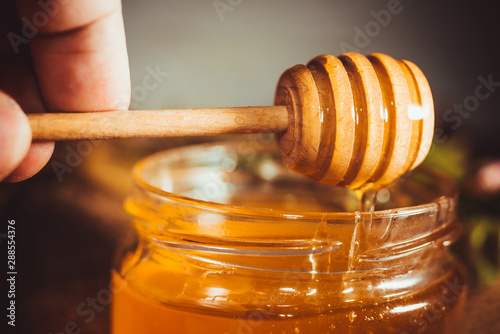 Wooden spoon and fresh liquid honey