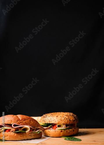 Delicious classic blt sandwiches with ham, cheese, bacon, tomatoes. Breakfast and fast food meal. on isolated black background wooden and text copy space.