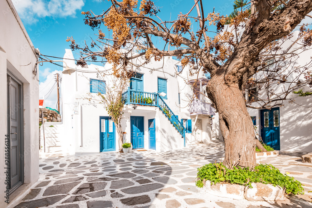Typical Greek architecture in the white, cobbled alleys of Mykonos town, houses in the old town of Chora with colorful balconies and white churches, Cyclades, Greece