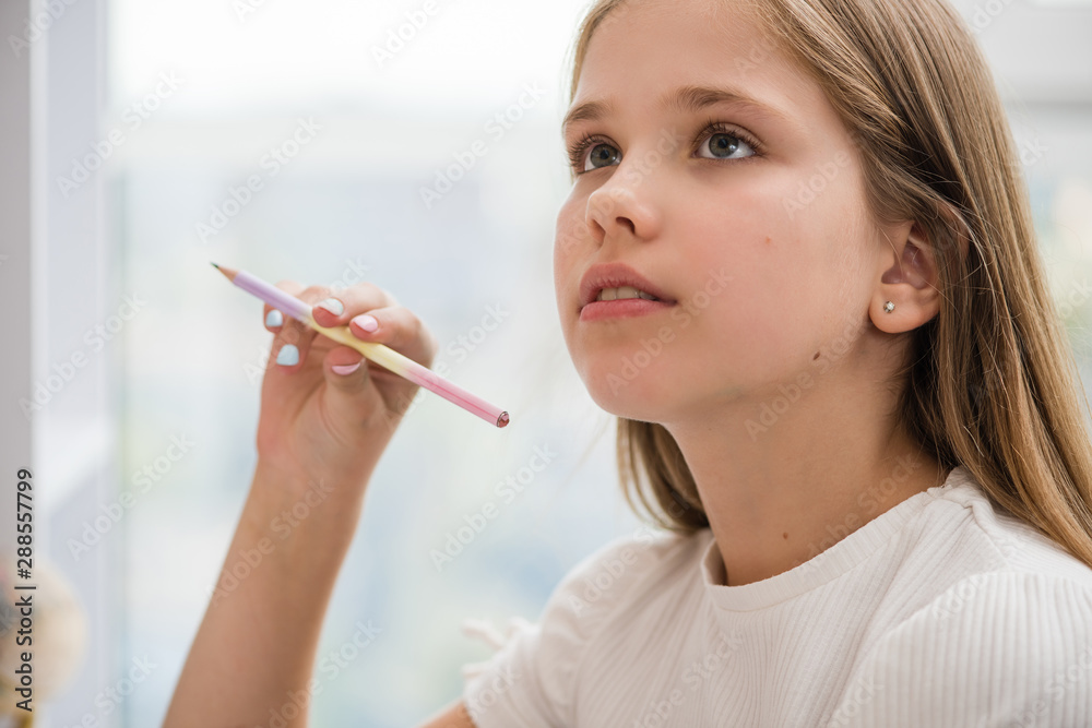 Inspired school girl look up pencil in right hand Inspired school girl look up pencil in right hand