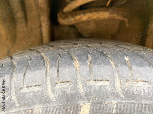 Close up of the tire of an dirty and used car wheel