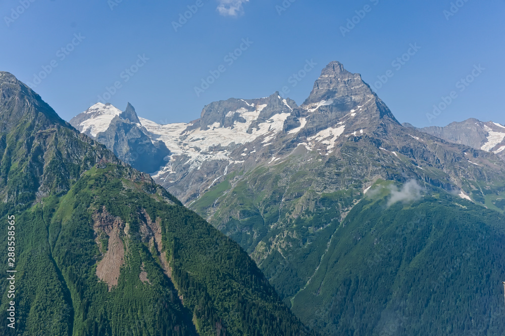 Fototapeta premium Mountain peak in black, covered with glaciers and snow. Dombay, Russia