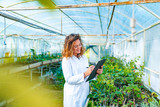 Young woman farming researcher standing in greenhouse