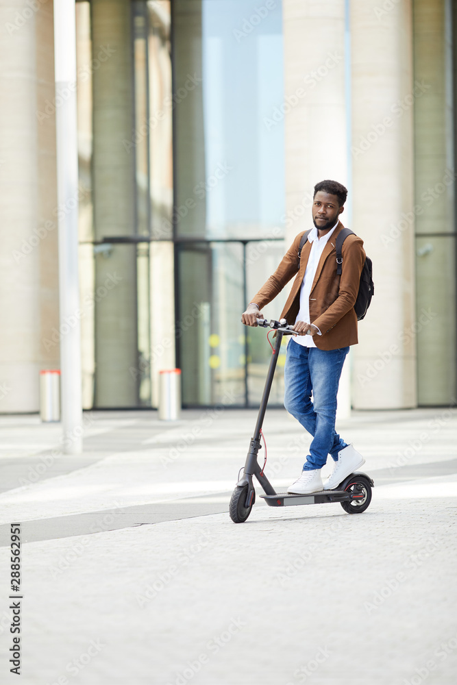 Generator Necklet specifikation Full length portrait of trendy African man riding electric scooter and  looking at camera while commuting in city street, copy space Stock Photo |  Adobe Stock
