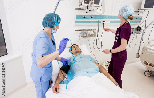 Doctors give resuscitation to a male patient in the emergency room. Cardiac massage